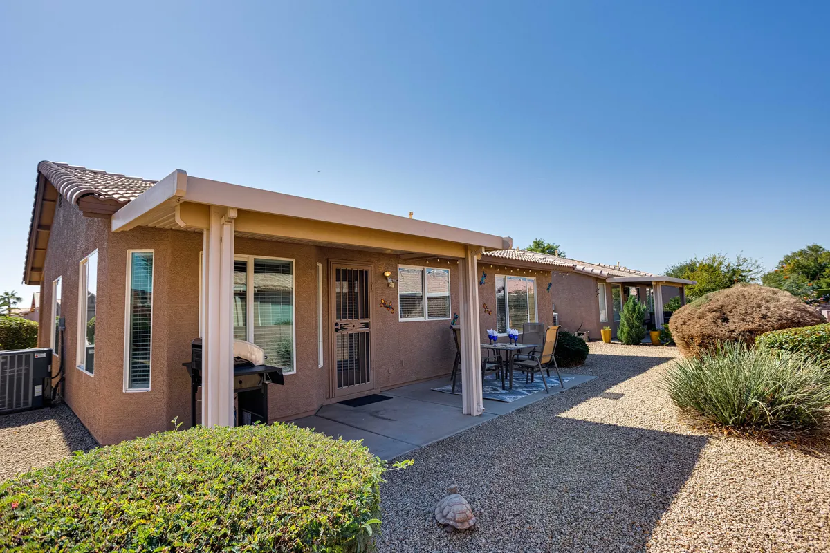 A well-maintained front entrance with an outdoor seating area and a landscaped garden. The scene exudes a welcoming atmosphere, ideal for relaxing with friends or enjoying a morning coffee while taking in the neighborhood surroundings.