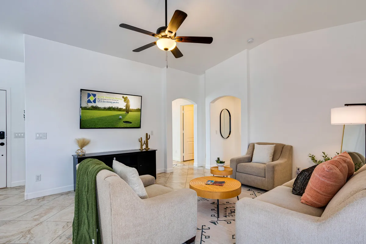 A cozy living room arrangement with a plush sofa, a coffee table, decorative plant, and a prominent large TV, inviting relaxation and group entertainment. The space is designed for socializing, movie nights, and shared experiences.